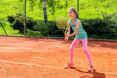 Tenis antrenmanı yapan tatlı küçük kız.