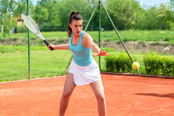 漂亮的姑娘全神贯注地打网球 — 图库照片