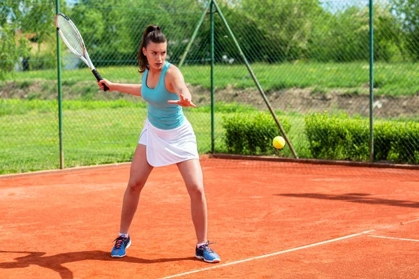 Krásná dívka plně koncentrované trefit tenisový míček — Stock fotografie