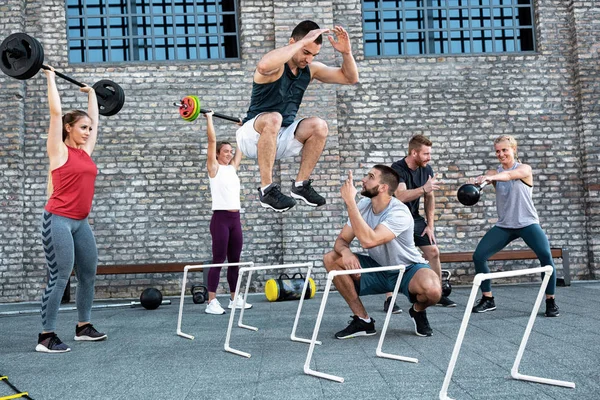 Jovem atleta saltando sobre obstáculos — Fotografia de Stock