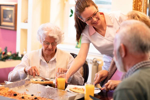 Szerető Nővér Szolgálja Időseket Miközben Vacsoráznak — Stock Fotó