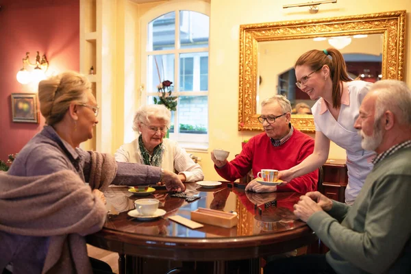 Pensionärer Som Tjänstgör Vid Bordet Som Sjuksköterska Tillgodoser Sina Behov — Stockfoto