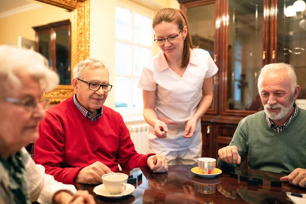 Ηλικιωμένοι Που Υπηρετούνται Στο Τραπέζι Νοσοκόμα Καλύπτει Τις Ανάγκες Τους — Φωτογραφία Αρχείου