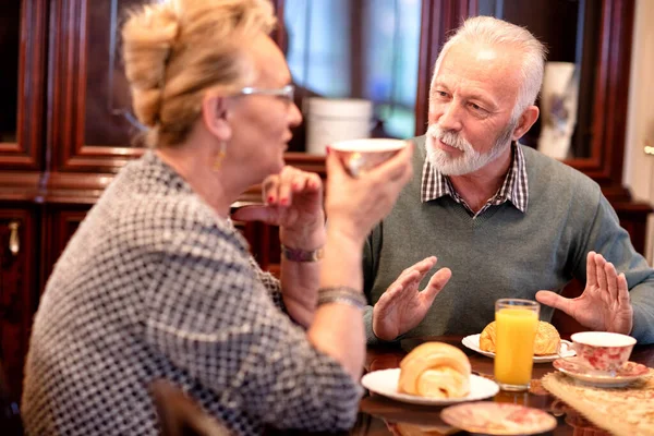 Senior Orang Memiliki Makanan Ringan Lezat Sambil Duduk Dan Berbicara Stok Gambar