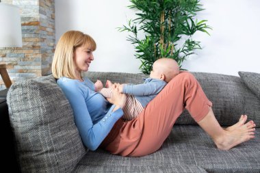 Anne ve küçük çocuğu kanepede oynuyorlar.