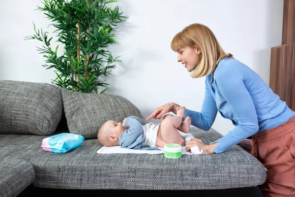 Genç anne bebeğinin altını değiştiriyor.