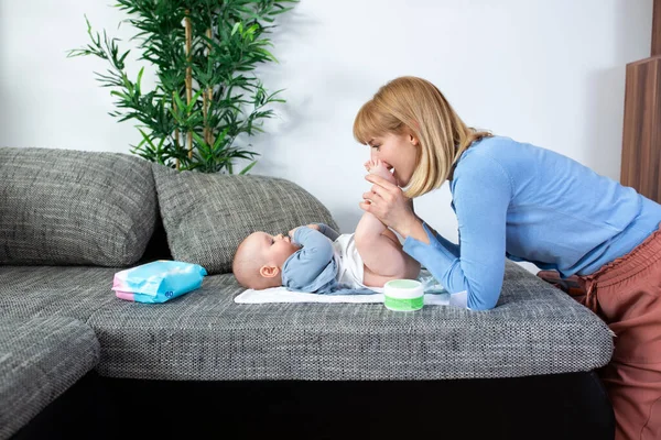 Genç anne bebeğinin altını değiştiriyor.