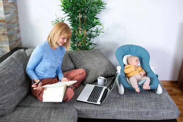 Küçük çocuğu yatakta oturan genç bir anne.