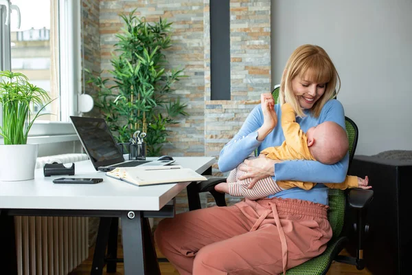 Annesi Çocuğu Ofiste Annesi Çalışıyor Bebeğini Kucağında Tutuyor — Stok fotoğraf