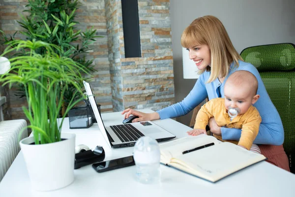 Ευτυχισμένη Νεαρή Μαμά Κάθεται Στο Γραφείο Και Κρατά Υπέροχο Μωρό — Φωτογραφία Αρχείου