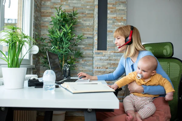 Mom and her baby in the office, working parents with children concept