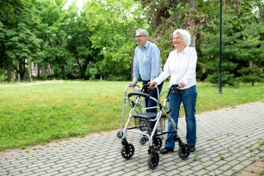 Senior people walking and enjoying a beautiful day in the park using walkers