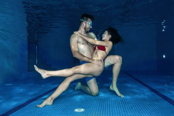 スイミングプールで二人の若者の間の水中ロマンス — ストック写真