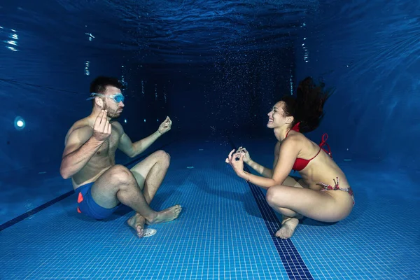 Underwater meditation, couple in the swimming pool, underwater relaxation concept