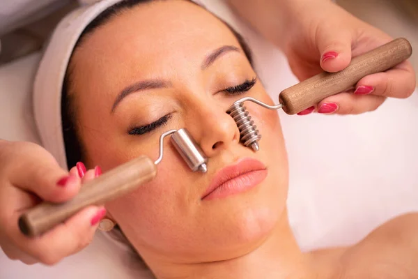 Facial massage with face skin care tools, a woman face massage close up