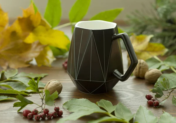 在木制和叶背的舒适温暖的一杯美味的茶 图库图片