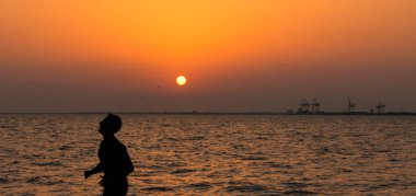 Bir adam koşu ile deniz gün batımı