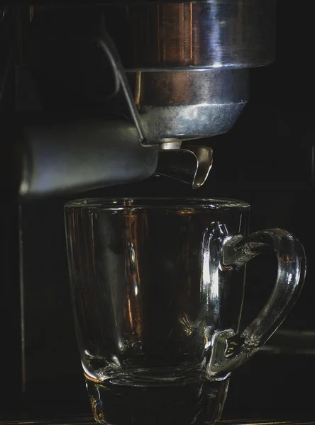 Boş espresso bardağı makinede, sıcak kahve demleniyor.