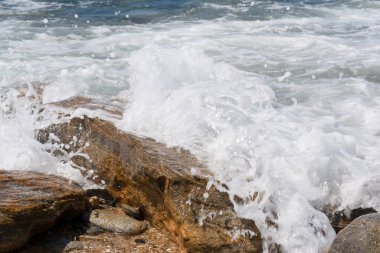Deniz suyu köpüğü Sıcak bir yaz gününde bir kıyı kayası