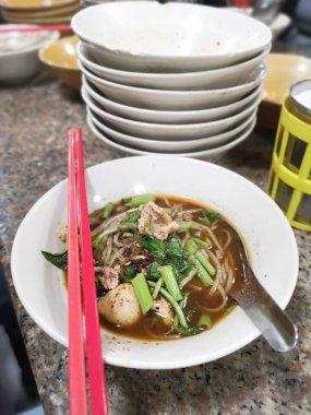 İnce kesilmiş beyaz pirinç kalınlaşmasına dilimlenmiş domuz eti ve domuz topu Tayland yemekleri ile tepesi çorbası 