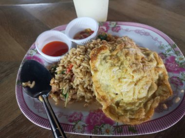 Tavada kızartılmış domuz eti ve fesleğen ile pirinç omlet yumurta tepesinde