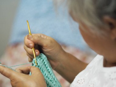 yetişkin yaşlı kadın bir şapka Crafts hobi ile örgülü saç üzerinde oturan kuluçka iğne yakalamak