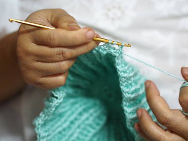 yetişkin yaşlı kadın bir şapka Crafts hobi ile örgülü saç üzerinde oturan kuluçka iğne yakalamak