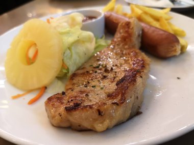 Beyaz tabak gıda Karabiber ve Domuz sosis ile Domuz Steak