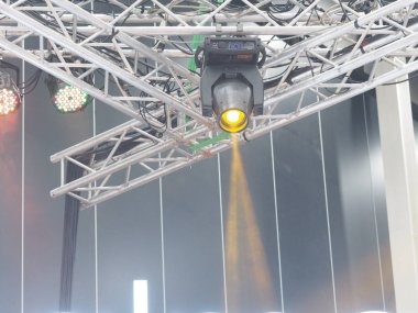 Metal çerçeve kirişine takılan dairesel spot ışığı konserde parlıyor.