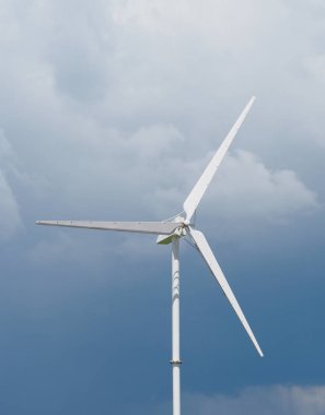 Jeneratör, güç ünitesi (Wpu), enerji dönüştürücü. Gökyüzünde çelikten yapılmış beyaz rüzgar türbinleri yavaşça dönüyor.