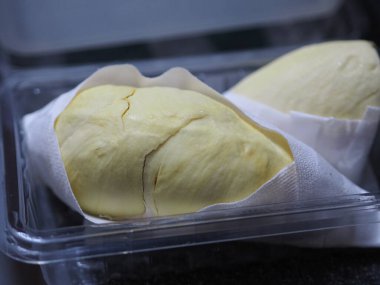 Durian, plastik bir kutu sarı tatlı meyve koy.