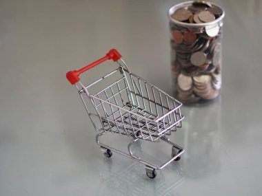 Süpermarketteki mini model arabalardan ve arka plandaki temiz plastik kutularda bir sürü bozuk para var.