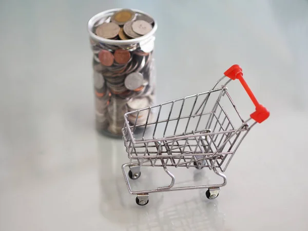 mini model cart type in the supermarket and Many coins are in clear plastic cans out of focus background