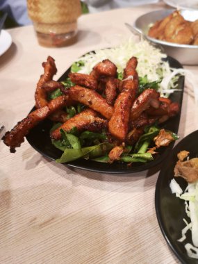 Friedkaffir limon yapraklı kızarmış domuz eti ve lahana, ince dilimlenmiş siyah tabak, Tayland yemeği mis kokulu yumuşak lezzetli
