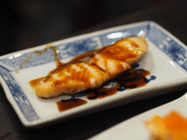 Beyaz tabakta tatlı soslu Aburi Saikyo Suşi, Japon yemeği.