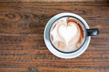 Tatlı bir kahve fincan sıcak siyah kapuçino gün ışığına temiz ahşap tablo. metin tasarım için alan. Aroma aşk kafein koku.