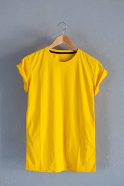 Retro kat sarı Pamuk T-shirt giysi renkli Mock yukarı grunge Beyaz ahşap arka plan kavramı üzerinde şablon perakende elbise dükkanı zemin, boş düz yatıyordu Vintage gri ahşap düz çamaşır reklam