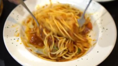 Kadınlar akşam yemeği için domates soslu spagetti pişirirken ellerini beyaz tabakta İtalyan yemeği konseptine koyuyorlar..