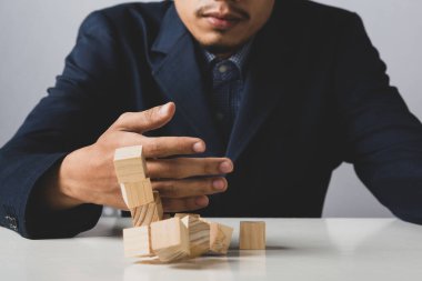 Girişimci iş adamının elinde tahta bloklar tutması, takım çalışması kavramı, strateji, profesyonel yönetici için çalışması temel servetin kurumsal yatırımcısı için.