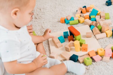 side view on adorable toddler playing with colorful cubes clipart