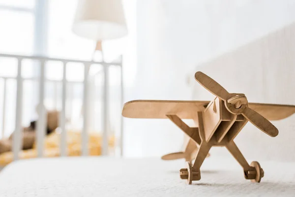 在托儿所房间的沙发上的复古木制玩具飞机 — 图库照片