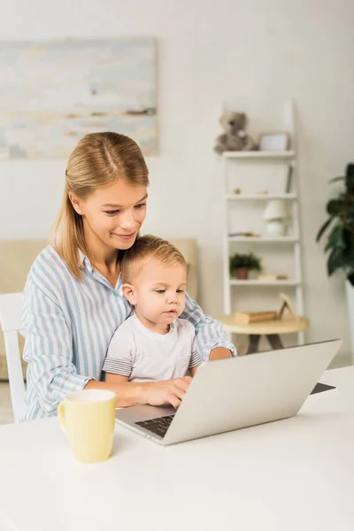 Mutter Sitzt Mit Süßem Kleinkind Schreibtisch Und Benutzt Laptop — Stockfoto