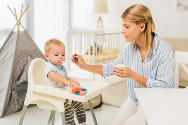 Madre Che Allatta Figlio Nel Seggiolone Con Cibo Bambini Nella — Foto Stock