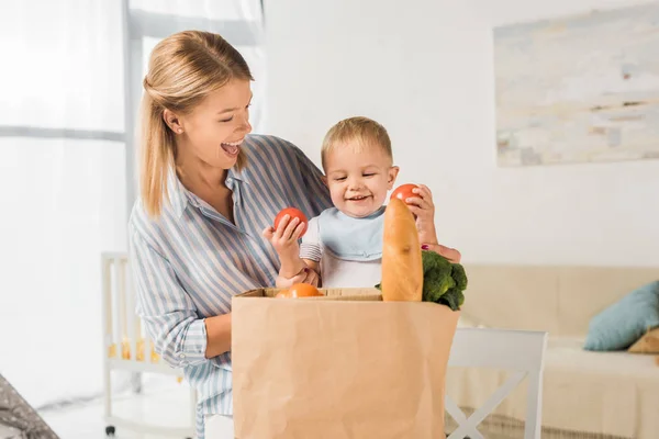 Šťastný Matka Ukazuje Potraviny Usmívající Synem — Stock fotografie