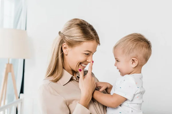 Cheerful Mom Holding Son Pointing Nose — Stock Photo, Image