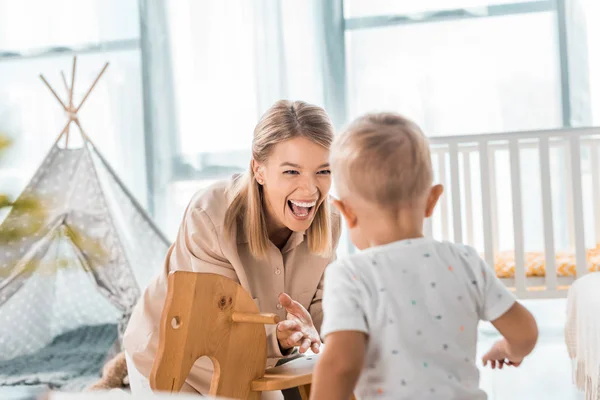 Happy Mother Toddler Playing Toy Wooden Rocking Horse Chair Nursery — Stock Photo, Image