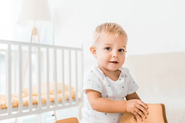 Entzückendes Kleinkind Sitzt Auf Spielzeug Holzpferd Und Blickt Die Kamera — Stockfoto