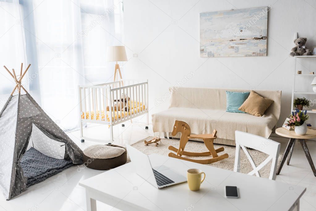 modern interior design of nursery room with baby wigwam and crib