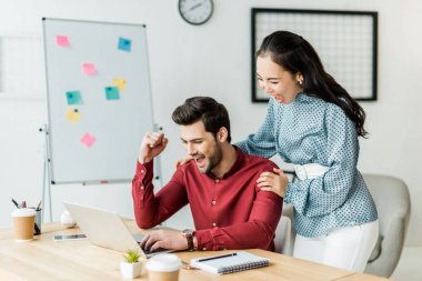 tezahürat ve dizüstü bilgisayar kullanma office heyecanlı çok ırklı iş arkadaşları