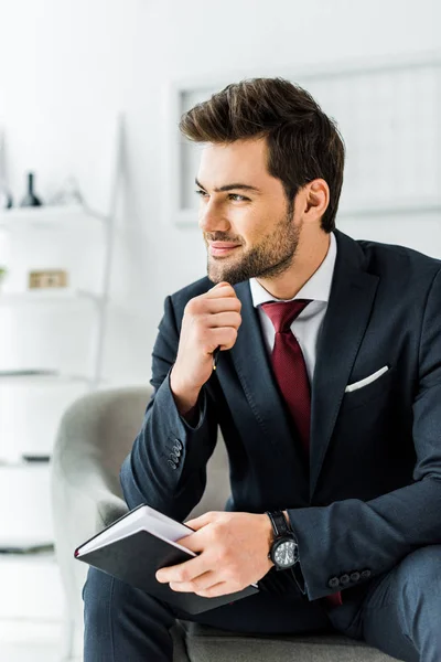 Schöner Lächelnder Geschäftsmann Formeller Kleidung Sitzt Mit Notizbuch Büro — Stockfoto